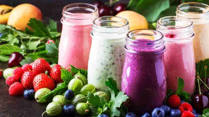 A vibrant, purple-hued Berry Mint Kefir Smoothie garnished with fresh mint leaves and whole berries, served in a tall glass.