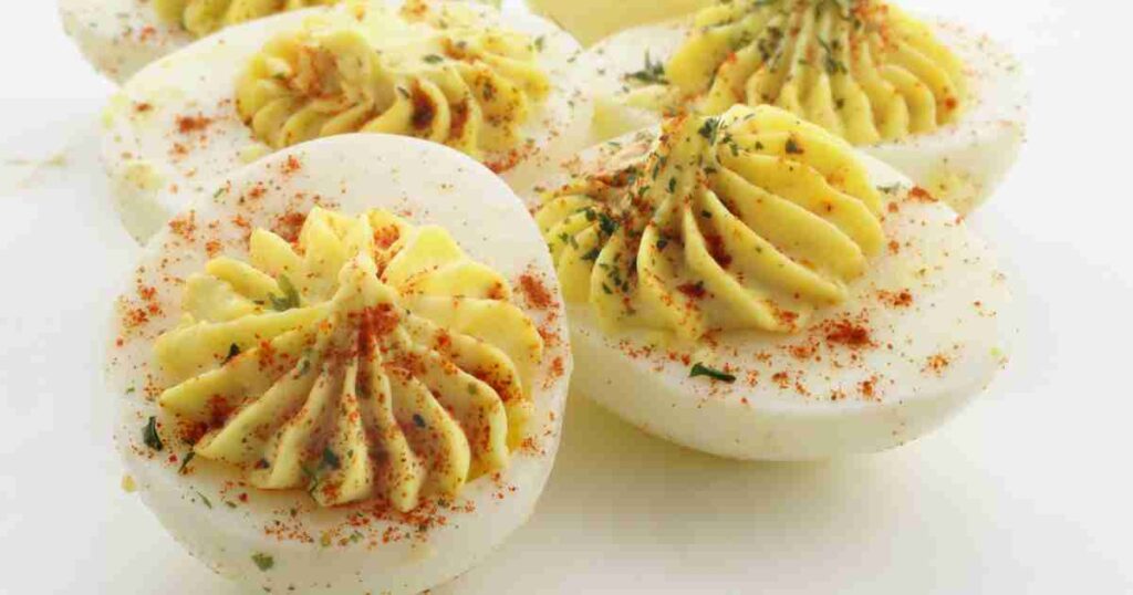 A platter of creamy deviled eggs garnished with paprika and fresh herbs. Creamy Deviled Eggs Creamy Deviled Eggs Creamy Deviled Eggs 1024x538
