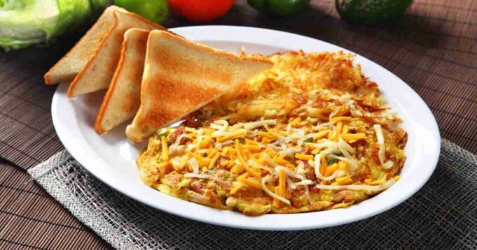 This fluffy egg white omelet is filled with fresh vegetables and served with golden-brown toast on the side.