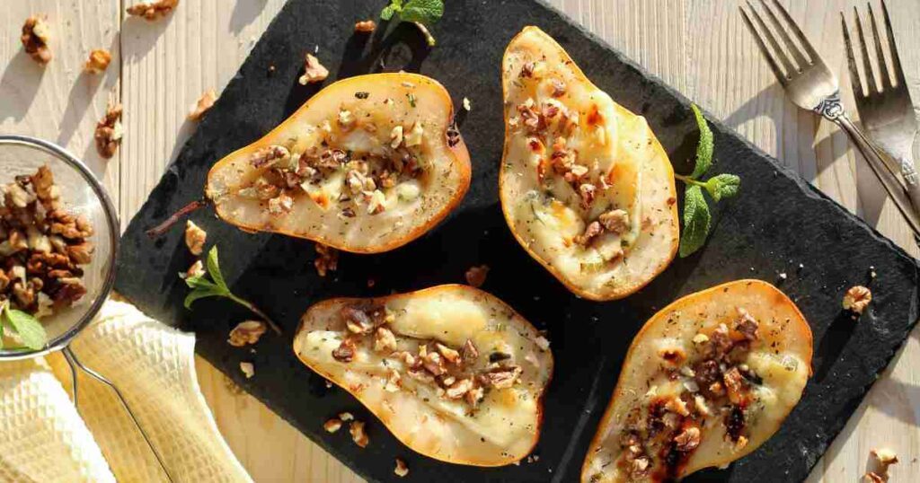 Honey-glazed pears topped with a golden nut mixture on a rustic white plate. honey nut crunch pears Honey Nut Crunch Pears Honey Nut Crunch Pears1 1024x538