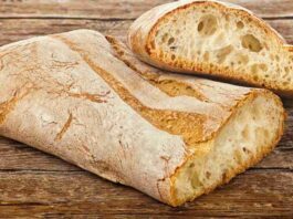 Freshly baked Rustic Italian Ciabatta Bread on a wooden board.