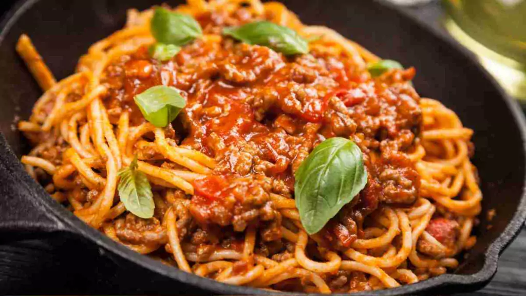 Hearty and savory big-batch bolognese sauce over pasta in a white bowl. big-batch bolognese Big-Batch Bolognese: A Hearty Feast for All Big Batch Bolognese1 1024x576