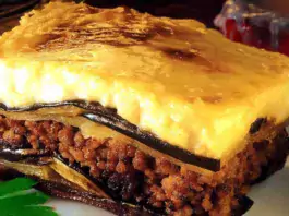 A healthy and delicious serving of low-fat moussaka with layers of eggplant, meat sauce, and creamy topping on a white plate.